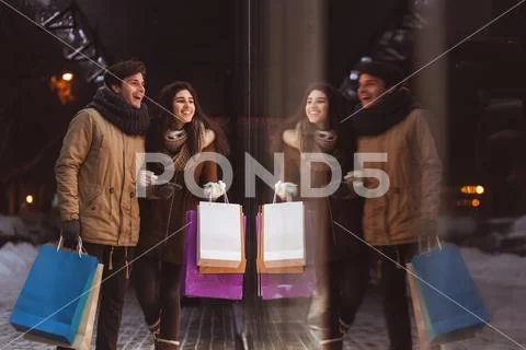 Boyfriend And Girlfriend Doing Shopping Walking In City In Evening Stock Photos
