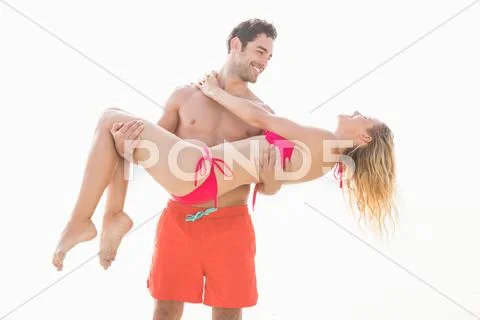 Boyfriend carrying his girlfriend on the beach Stock Photos