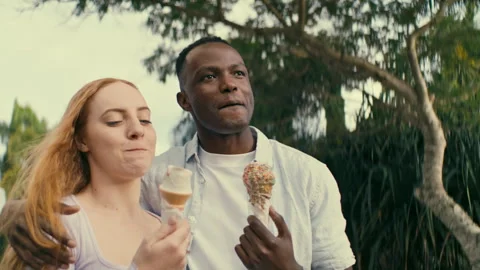 Boyfriend hugging his girlfriend while eating ice cream together Stock Footage 264032740