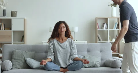 Boyfriend screams at girlfriend while she does meditation practice Stock Footage 241692046