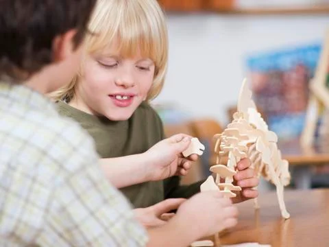 Boys (4-7) assembling dinosaur skeleton Stock Photos