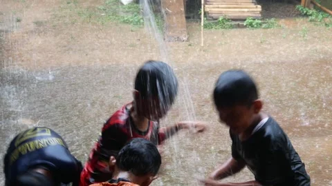 Boys are having fun playing in the rain in the yard. Stock Footage 308962930