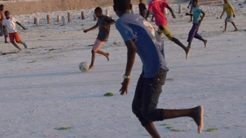 Boys are playing football, soccer on the beach in africa Stock Footage