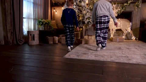 Boys checking presents under Christmas tree Stock Footage
