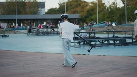 Boys Doing Scooter Tailwhip and BMX Tricks in Skate Park Video stock 346157059