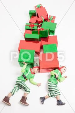 Boys dressed Elf costumes holding many gift boxes. Black Friday Stock Photos