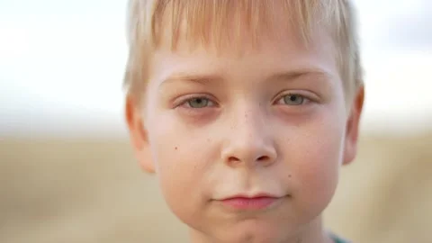 Boy's face close-up looks into camera lens. Blond-haired boy with freckles close Stock-Footage 238896534