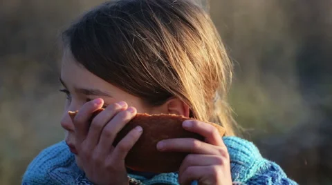 The boys face closeup with bread in his hands. Hungry boy eating white bread. Stock Footage 58899404