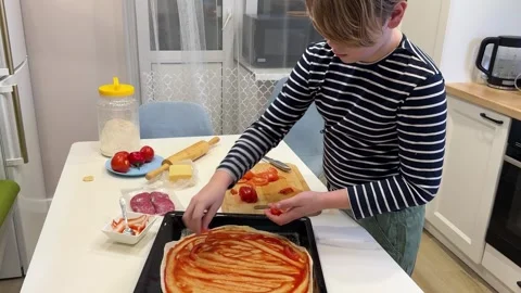 A boys first attempt at pizza-making turns into Stock Footage 302932314