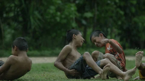 Boys getting up while playing on a wet lawn, Guatemala Stock Footage 63052660