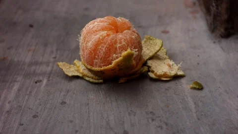 A boy's hand is picking up an orange that has been peeled. Stock-Footage 255029905