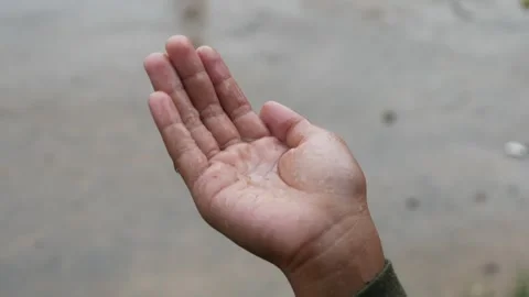 Boys hand playing with falling raindrops Stock Footage 308395004