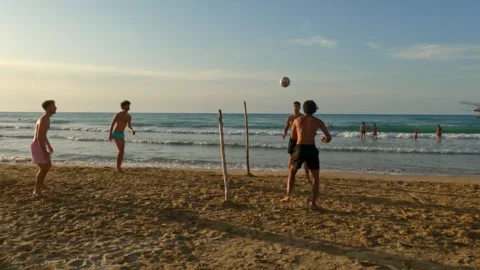 Boys having fun playing beach football at punta penna Stock Footage 280884042