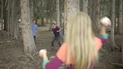 Boys Hide Behind Trees, Their Girlfriends Throw Snowballs At Them In Summer Stock-Footage 51889326