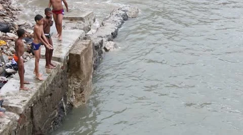 Boys Jump off Wall into Ocean Stock Footage 9276000