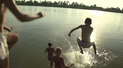 Boys jumping into the water Stock Footage