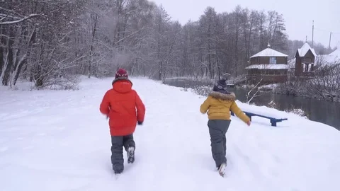 Boys  l in the winter run through the forest. Slow motion Video stock 99961416