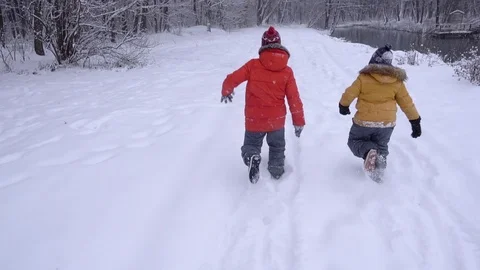 Boys  l in the winter run through the forest. Slow motion Stock-Footage 99962217