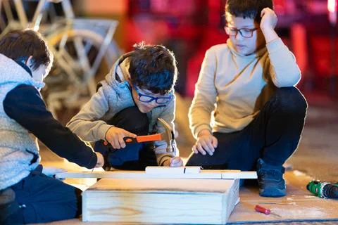 Boys learning carpentry skills creating wooden crafts Stock Photos