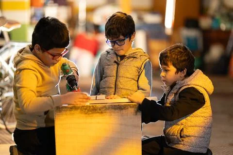 Boys learning woodworking skills using power tools Stockfoto's