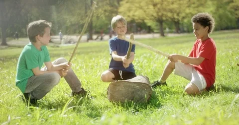 Boys in park playing with sticks Stock Footage