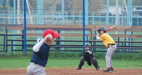 Boys play baseball at school, the pitcher throws the ball toward a batter Stock Footage