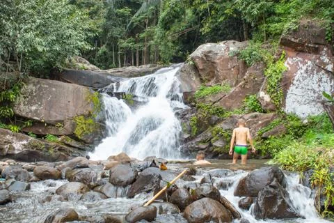 The boys play the waterfall that flows down from the mountains. at Phu SOI DA Stock Photos