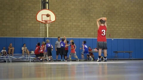 Boys playing basketball in an indoor gym. Stock Footage