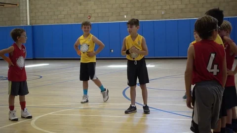 Boys playing basketball in an indoor gym. Stock Footage