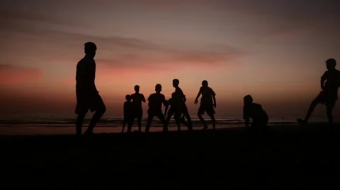 Boys playing on beach during sunset Stock Footage 61139991