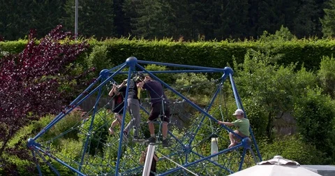 Boys playing on a rope climber at a playground in Austria, 4K Stock Footage 79934406