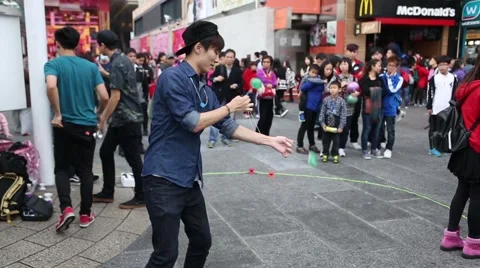 Boys playing with a toy yo-yo on the waterfront of Hong Kong Vídeos de archivo 48991748