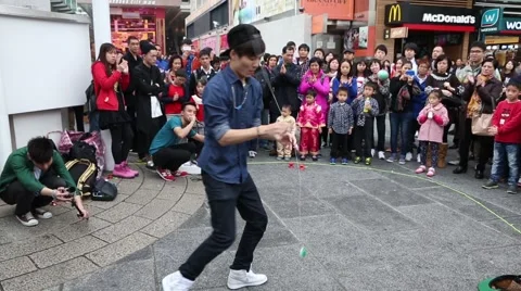 Boys playing with a toy yo-yo on the waterfront of Hong Kong Stock Footage 48992619