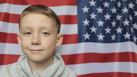 The boy's portrait against the background of the American banner. Close up Vidéo 75056953