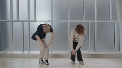 Boys practicing new dance moves. Curly twin brothers performing synchronized Stock Footage 231675325