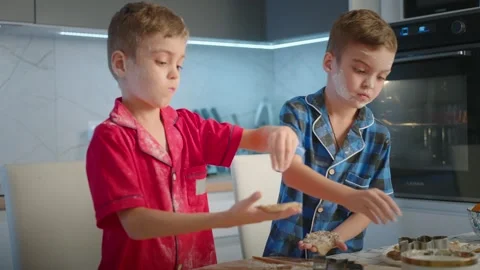 Boys preparing cookies in a modern kitchen with colorful ingredients Video stock 307121891