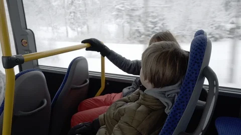 Boys riding on bus on snowy day in Germany Stock Footage 121754340