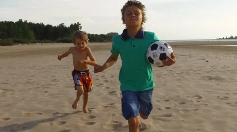 Boys running on the beach in slow motion Stock Footage 64598007