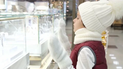 Boys in Santas hat looks into the store through the window in market. glowing Stock Footage 163846889