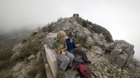 Boys snack with mom on top of cloudy mountain in Croatia Stock Footage 102226677