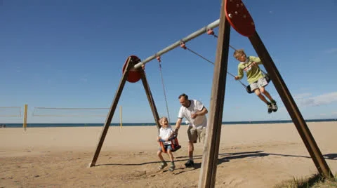 Boys swinging on a swing with dad Stock Footage 24774267