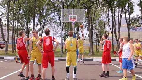 Boys take turns throwing the balls into the basket Stock Footage 72296715