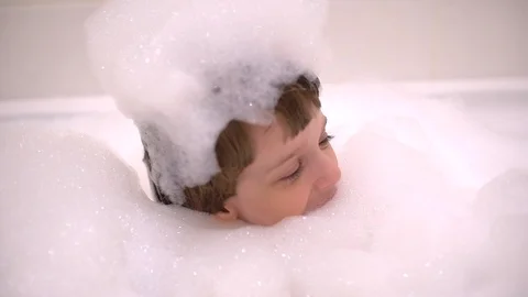 Boys using bath bubbles to give himself funny hairstyle, Portrait of child Stock Footage 101334769