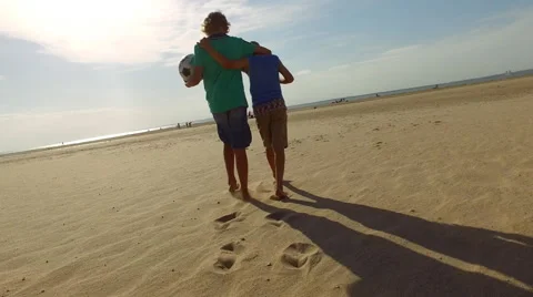 Boys walking on the beach together Stock Footage 64597858
