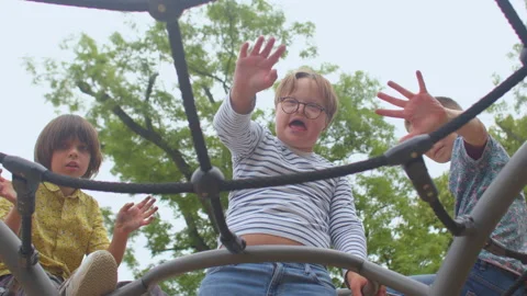 The boys wave to the camera affably. A child with glasses has Down syndrome. Video stock 157610830
