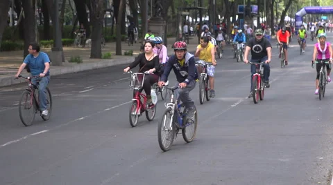 BPMX11-Mexico, overweight man rides bike. Tripod, pan, wide. Hundreds in the BG. 스톡 동영상 47853054