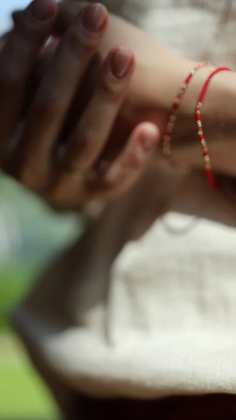 A bracelet made of red thread on the wrist of a woman's hand 스톡 동영상 246549340
