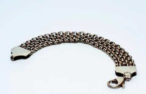 Bracelets, chains and crosses of silver on a white background Stock Photos