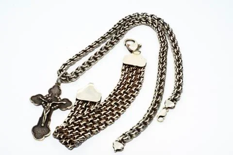 Bracelets, chains and crosses of silver on a white background Stock Photos