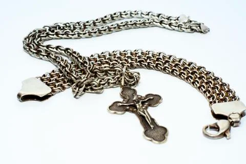 Bracelets, chains and crosses of silver on a white background Stock Photos